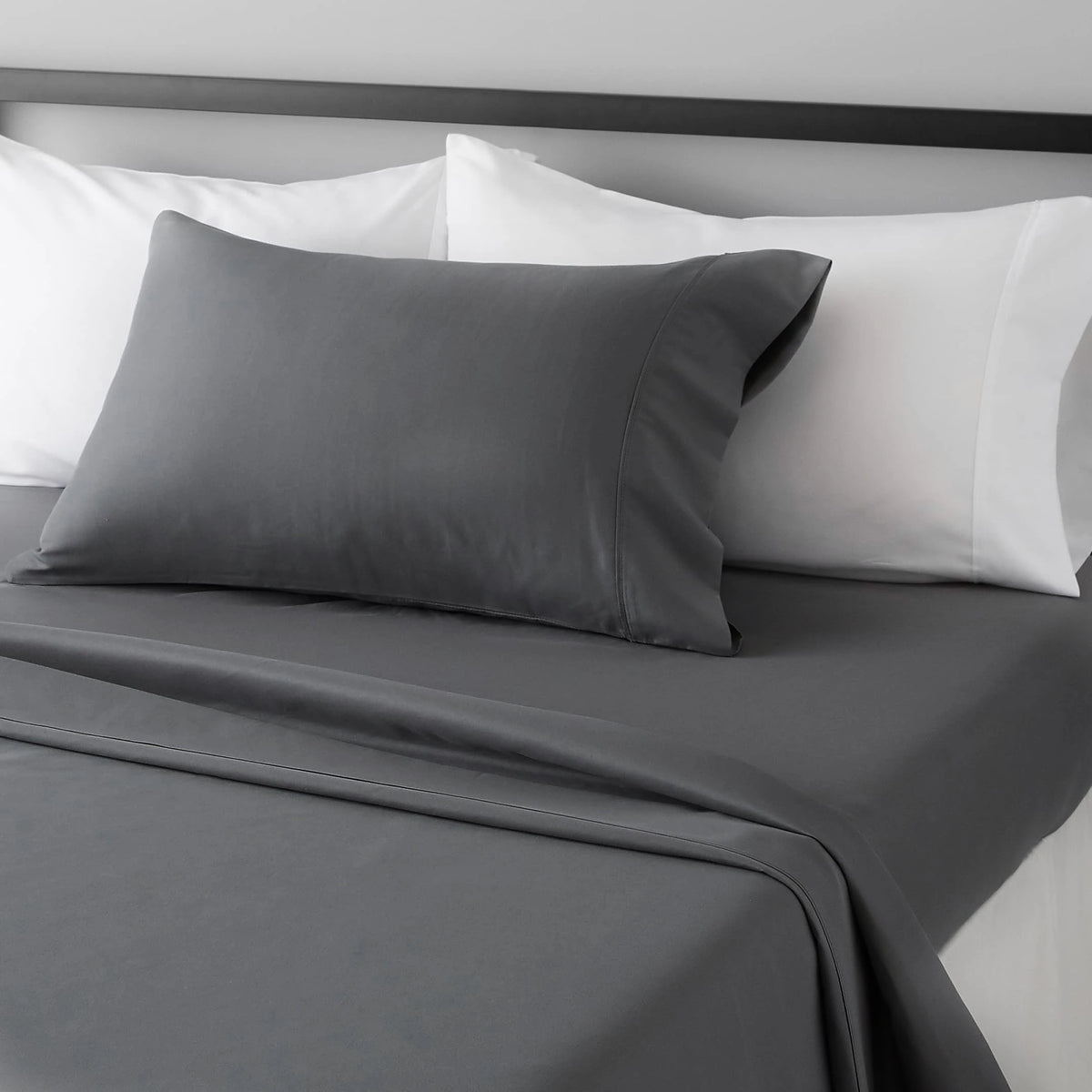 A gray microfiber flat fitted sheet set with white pillows and a matching gray duvet on a bed.