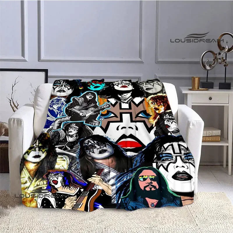 A printed flannel travel blanket featuring a collage of stylized faces and dark artwork.