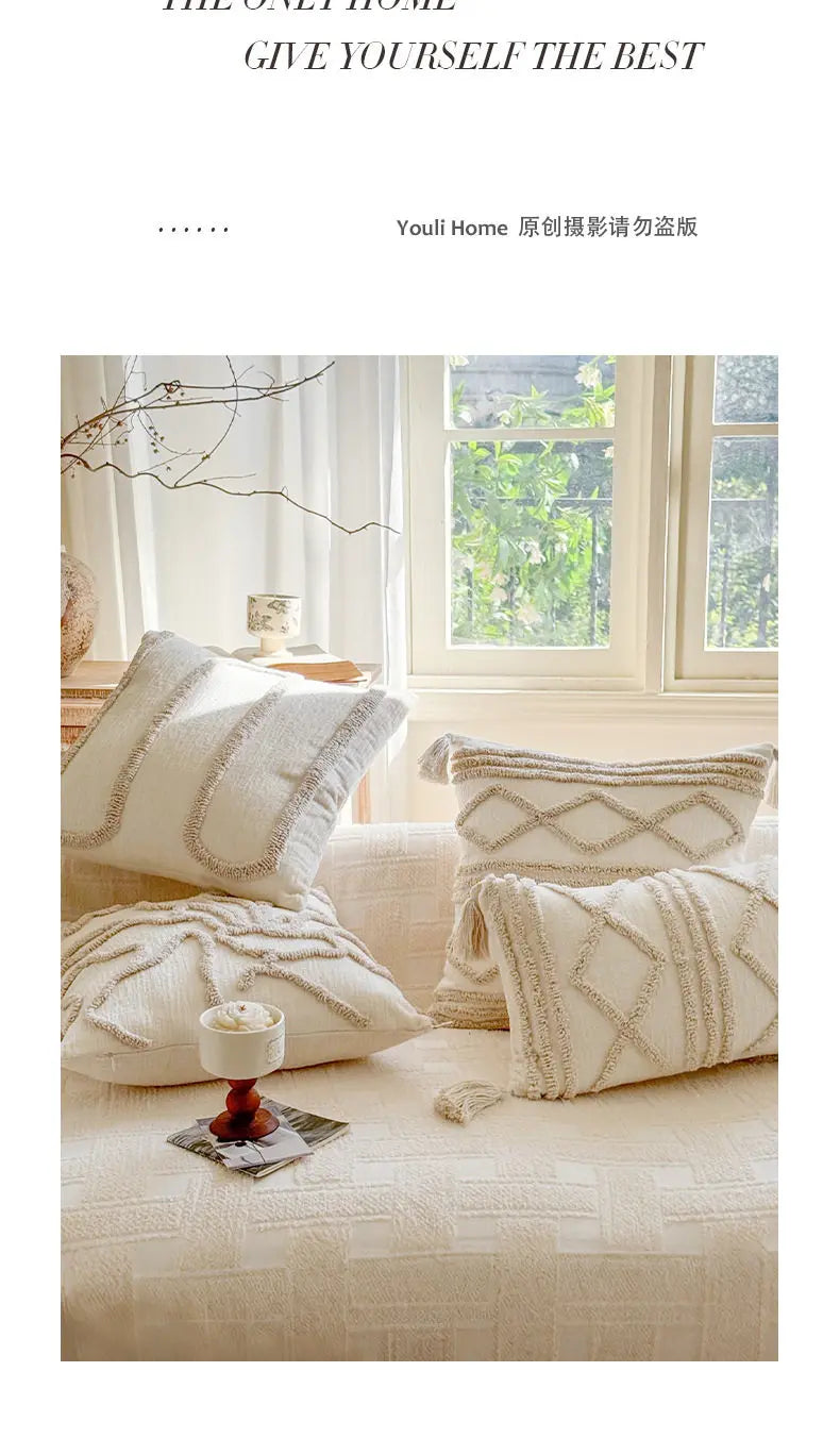 A collection of cream and beige knit pillow covers with geometric patterns displayed on a light-colored sofa.