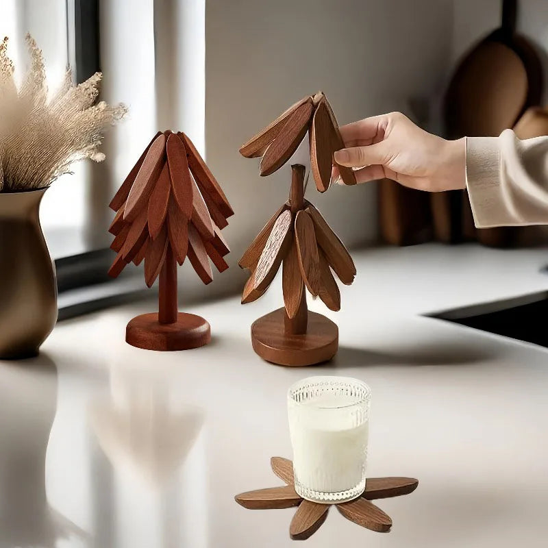 Wooden tree-shaped placemats and a wooden coaster are displayed on a white table.