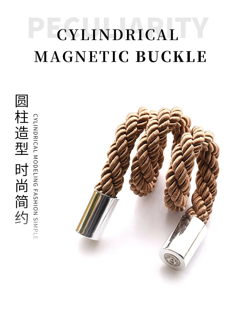 A close-up of a brown cylindrical magnetic buckle featuring a twisted cord design.