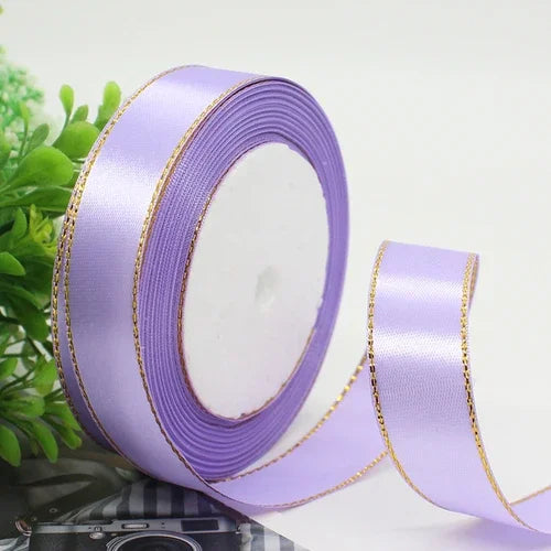 Roll of light purple satin ribbon with a gold edge for gift wrapping and crafts