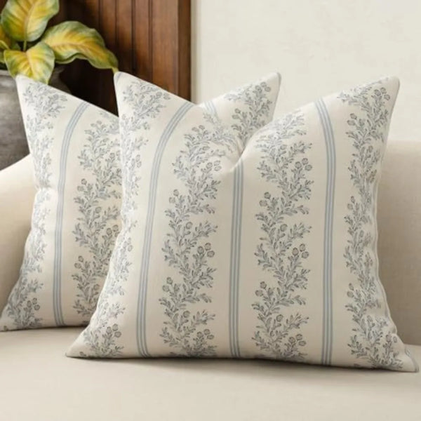 A close-up of a vintage striped floral throw pillow cover with gray and white botanical patterns.
