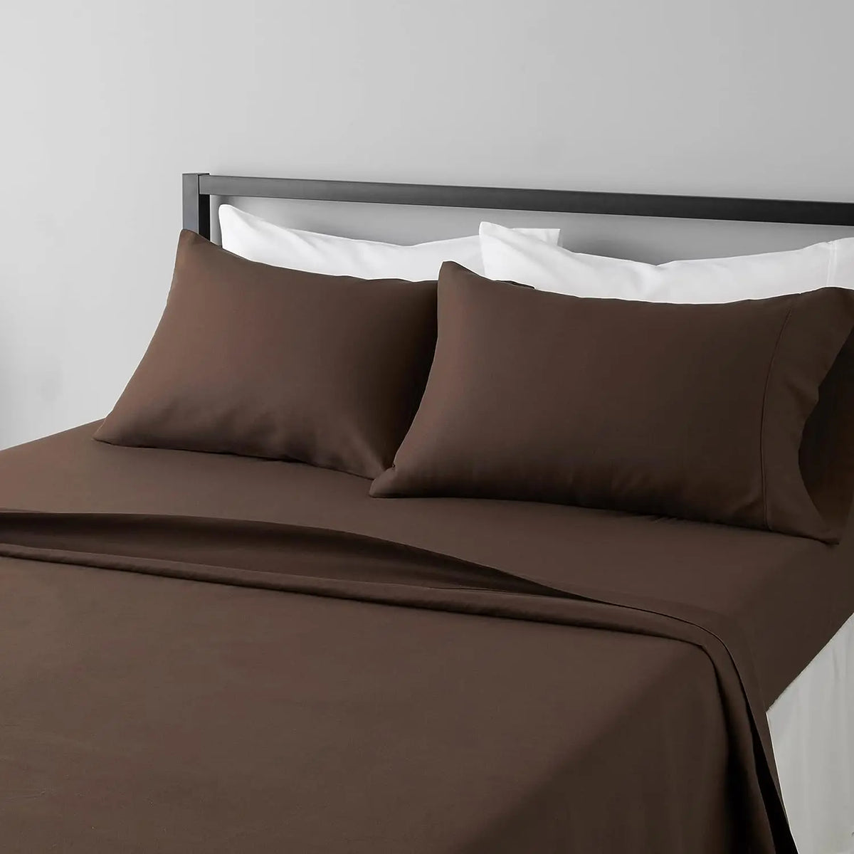 A brown microfiber flat fitted sheet set with white pillows on a bed.