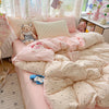 A pink polka dot duvet cover set with matching pillowcases and stuffed animal toys on a bed.