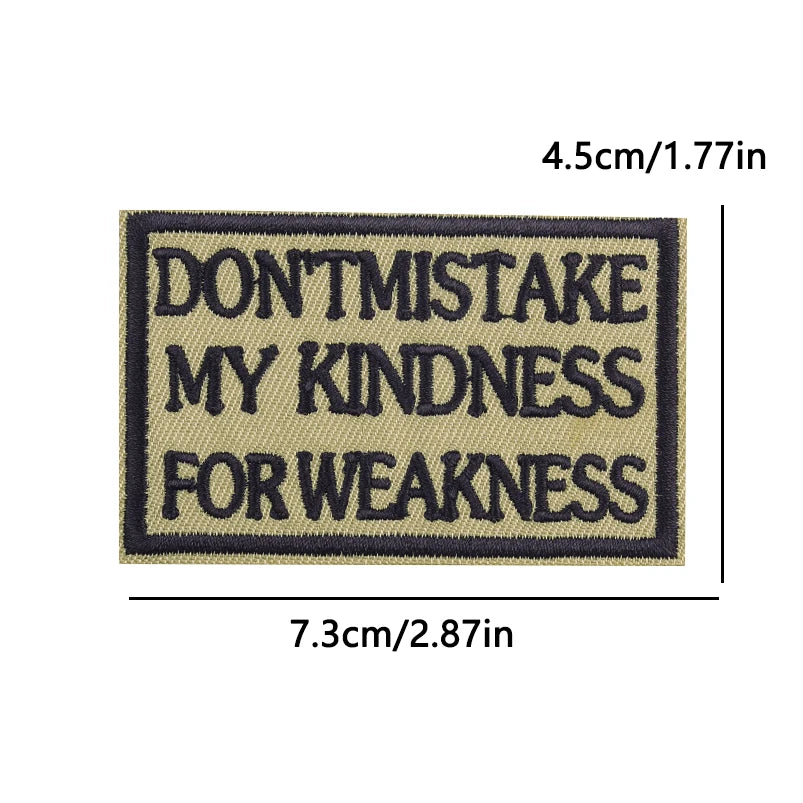 A rectangular embroidery patch with dark blue text on a tan background that reads DON'T MISTAKE MY KINDNESS FOR WEAKNESS