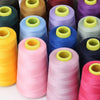 A collection of colorful sewing thread spools in various shades including yellow, green, purple, blue, and pink.