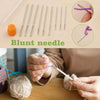 A set of blunt needles and a crochet needle being used for knitting or stitching.