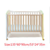 A wooden crib with a protective mesh and clear plastic mosquito net covering the sides.