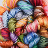 A vibrant pile of gradient embroidery thread in various colors including orange, pink, blue, green, and red.