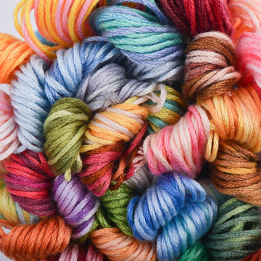 A vibrant pile of gradient embroidery thread in various colors including orange, pink, blue, green, and red.