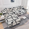 L-shaped sofa protector covers featuring a black and white geometric pattern on a gray rug.