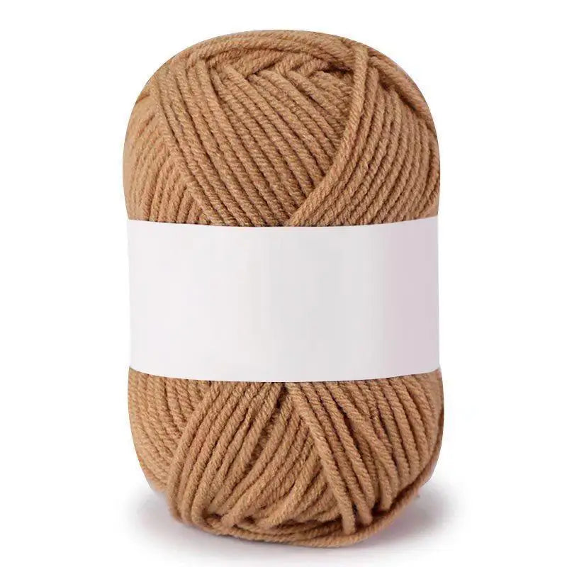 A ball of soft milk cotton knitting yarn in a natural beige color.