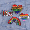 Three heart-shaped embroidered patches featuring rainbow and pride colors with the text Love is Love and Sounds Gay