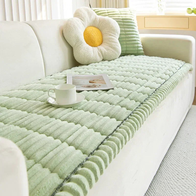 A light green quilted fabric cover is placed on a white sofa armrest, featuring a yellow flower cushion.