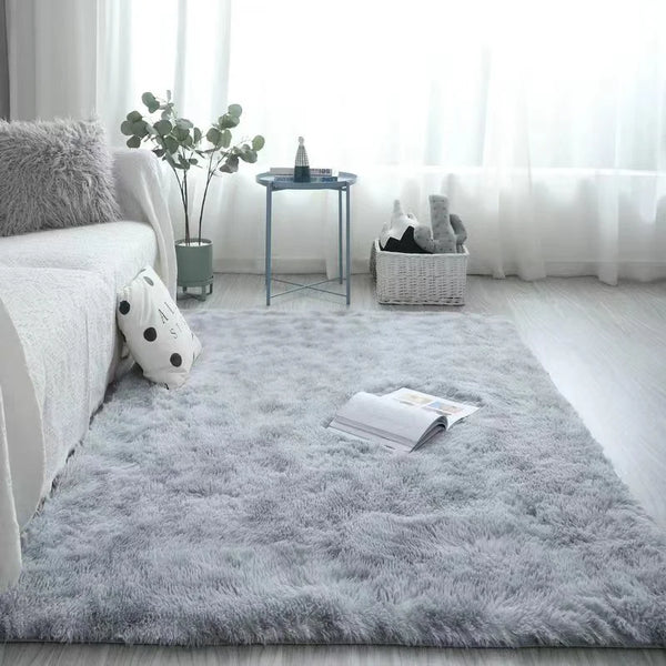 A fluffy gray silk wool floor rug placed on a light wooden floor near a window with soft natural light.