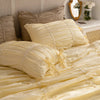 A set of pure white princess ruffle cotton bedding featuring layered fabric and decorative stitching.