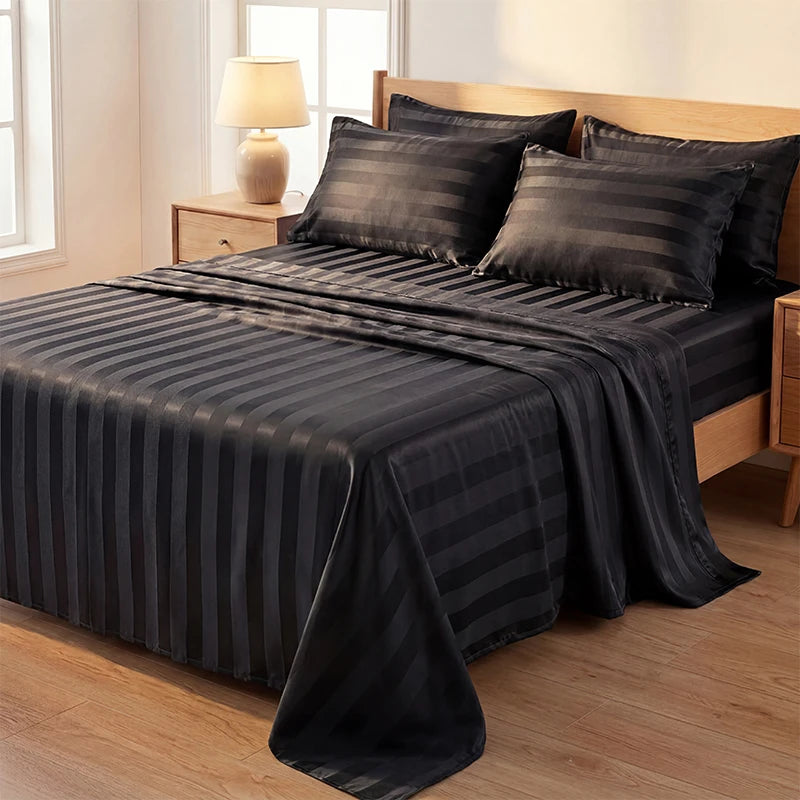 A dark gray striped satin bedding set spread on a wooden bed with a lamp in the background.