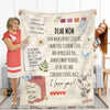 A soft printed throw blanket featuring inspirational text and floral designs, displayed on a couch.