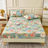 A floral fitted sheet set with light green fabric and pink, orange, and blue flowers displayed on a bed.