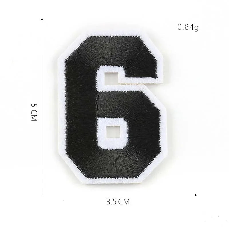 A black embroidered number 6 patch with white stitching on a white background.