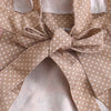 A beige floral patterned kitchen apron with adjustable straps tied in a bow.