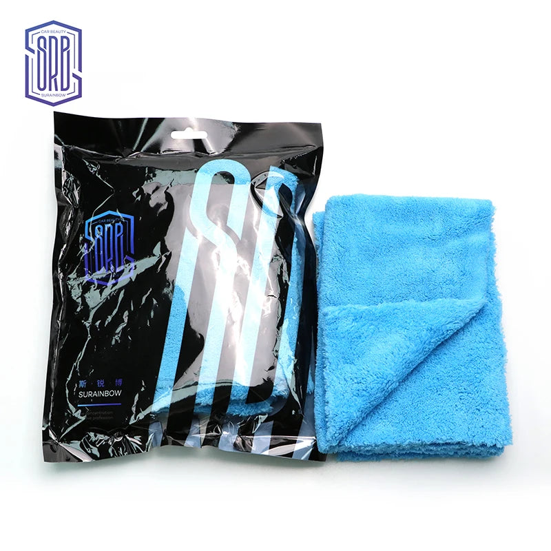 A black package of coral fleece microfiber cleaning cloths and a blue towel are displayed on a white background.