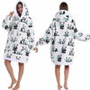 A woman models an oversized white patchwork fleece hoodie with black panda print on the front and hood.