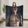 A man with gray hair and intense expression is featured on a dark graphic throw blanket.