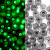 A close-up view of green glow-in-the-dark glass seed beads, some appearing bright green and others dark gray.