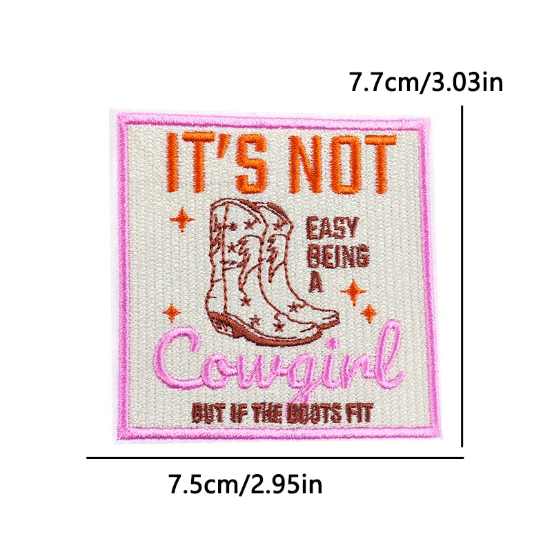 Pink embroidered patch with text saying It's Not Easy Being A Cowgirl But If The Boots Fit