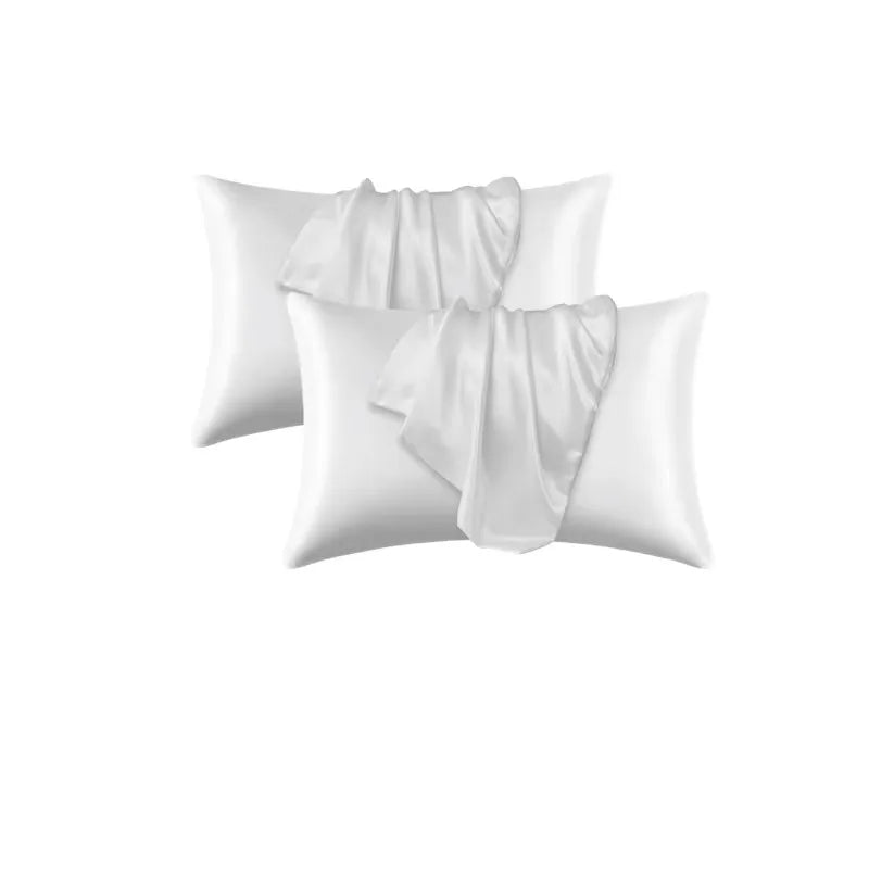 A stack of white satin pillowcases with draped fabric texture.