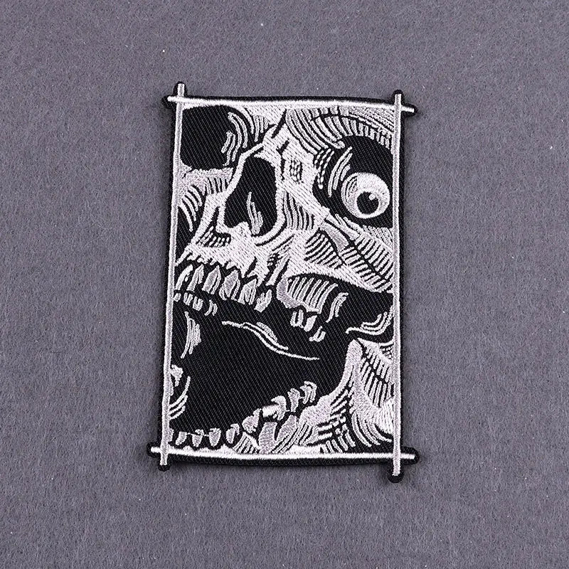 Black embroidered skull patch with white detailing on a fabric backing