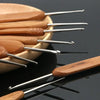 A set of bamboo crochet knitting needles with silver tips resting on a dark surface.
