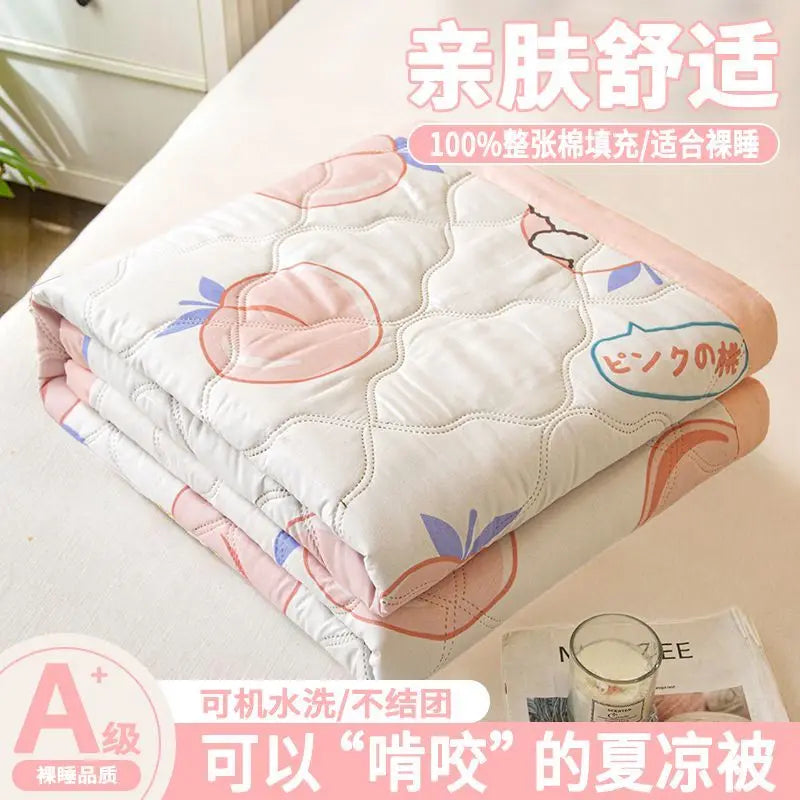 A stack of white and pink quilted blankets or quilts for dorms