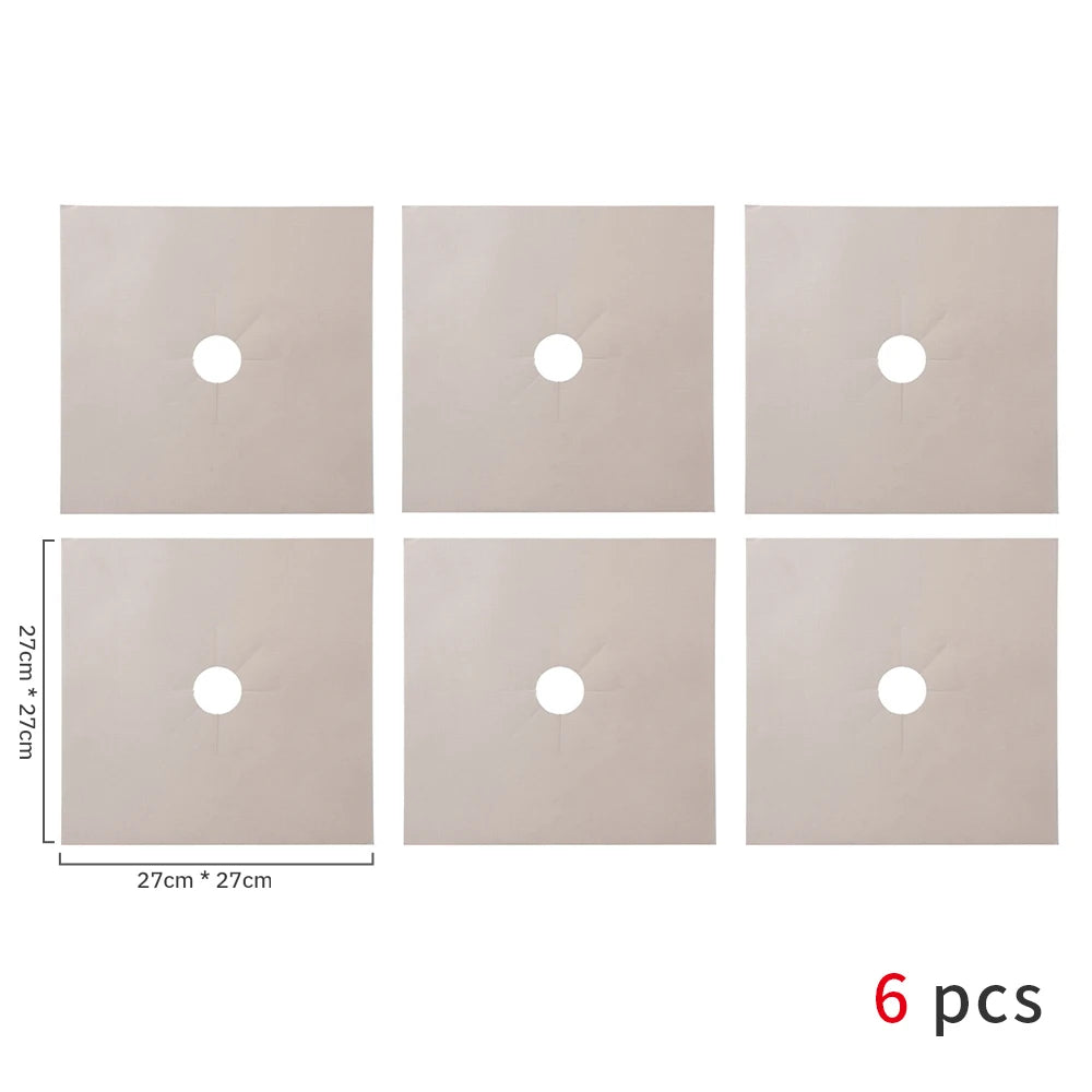 A set of six square, light beige gas stove protectors with circular openings.