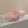 A pink cooling memory foam cervical pillow resting on a white surface.