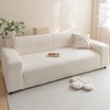 A cream-colored, textured sofa cover displayed on a light rug in a bright room.