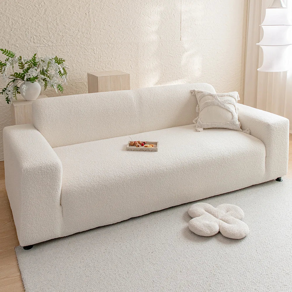 A cream-colored, textured sofa cover displayed on a light rug in a bright room.