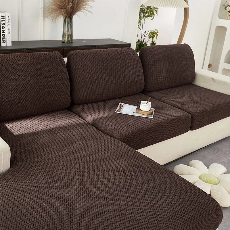 A dark brown jacquard knit sofa cushion cover is shown on a light-colored sofa.