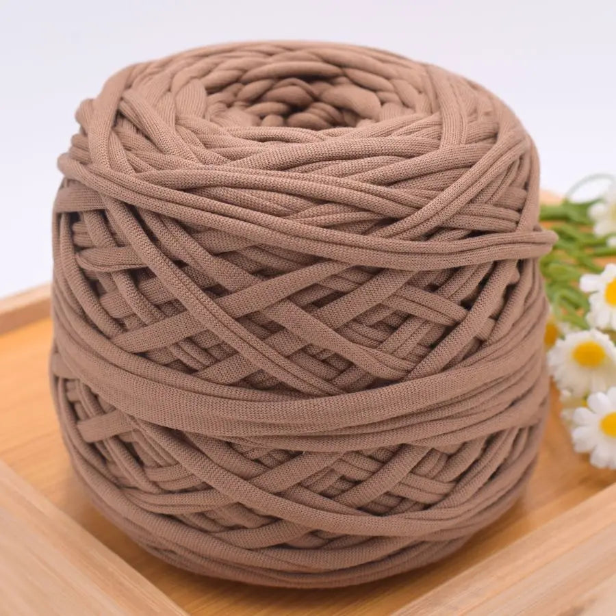 A ball of brown craft yarn made of 100% polyester for knitting and DIY projects.