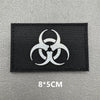 A black embroidered patch featuring a white biohazard symbol on a gray background.