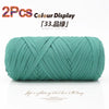 A skein of teal colored elastic yarn is shown rolled up for crafting.