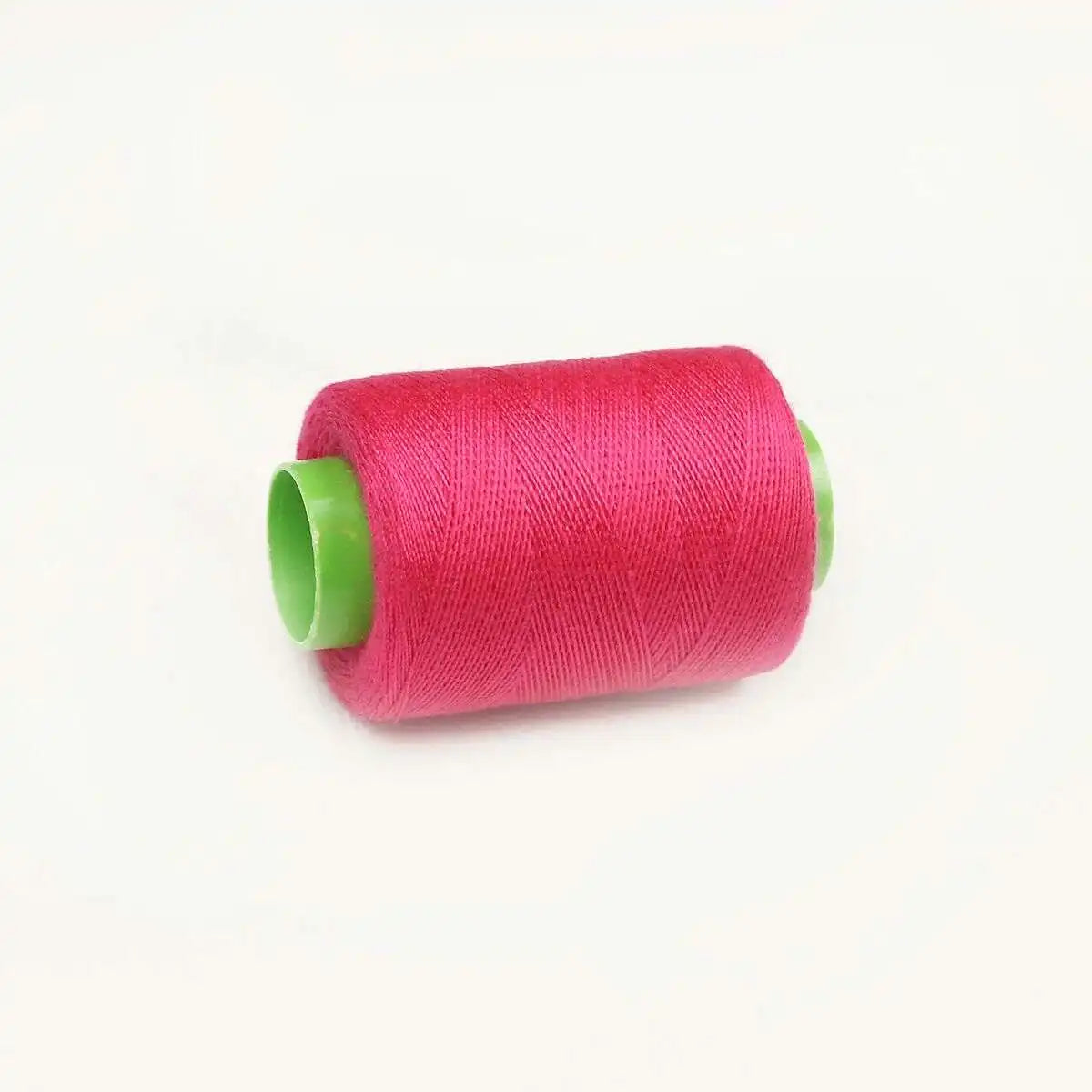 A roll of bright pink sewing thread with a green core.