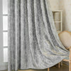 Gray blackout curtains featuring a tree bark pattern draped next to a light wood chair.