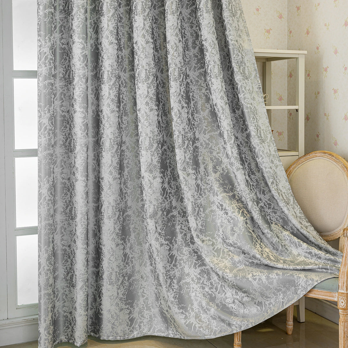 Gray blackout curtains featuring a tree bark pattern draped next to a light wood chair.