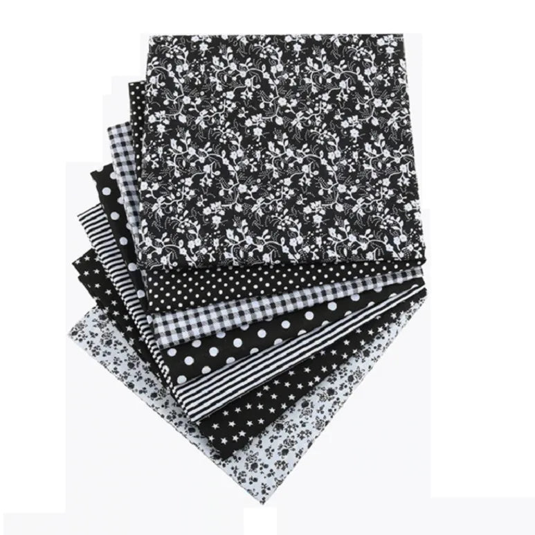 A stack of black and white floral dot pattern cotton fabric squares for DIY crafting.