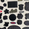 A collection of five black embroidered leather patches with self-adhesive backing, featuring various shapes and text like SPO
