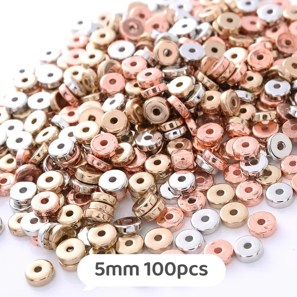 A pile of small, round geometric acrylic beads in various rose gold and silver colors for jewelry making