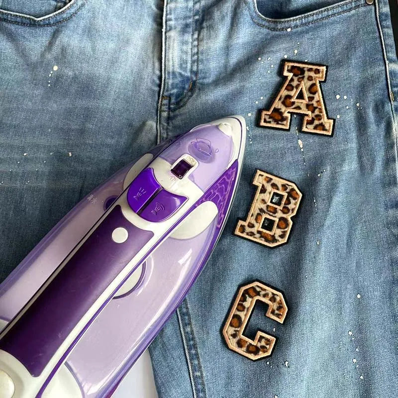 A purple and white iron-on patch featuring the letter A, B, and C in leopard print.